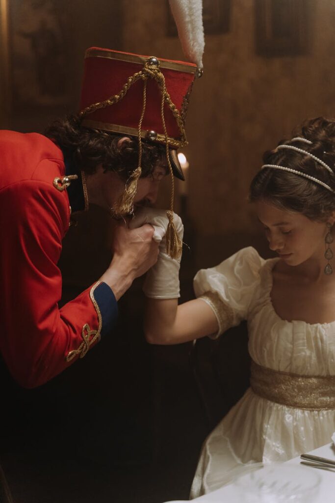 A man in a hussar costume kisses a woman's hand in a classic period setting.